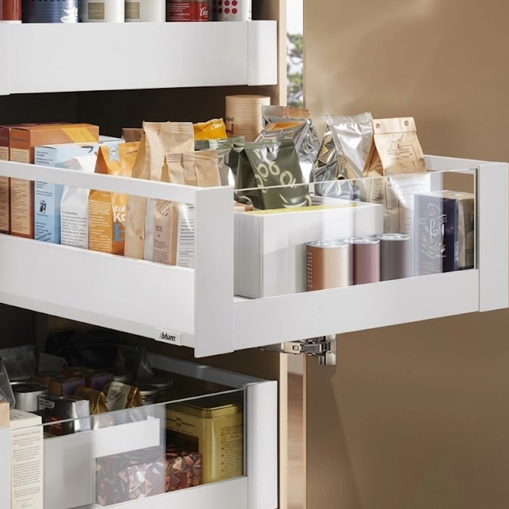 Geöffneter Vollauszug in einem Küchenschrank mit Vorratspackungen, Dosen und Einsatzboxen, darunter eine zweite Schublade.